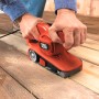 Black+Decker Bandschleifer KA86 im Einsatz auf Holz. Die Schleifmaschine ist rot und schwarz.