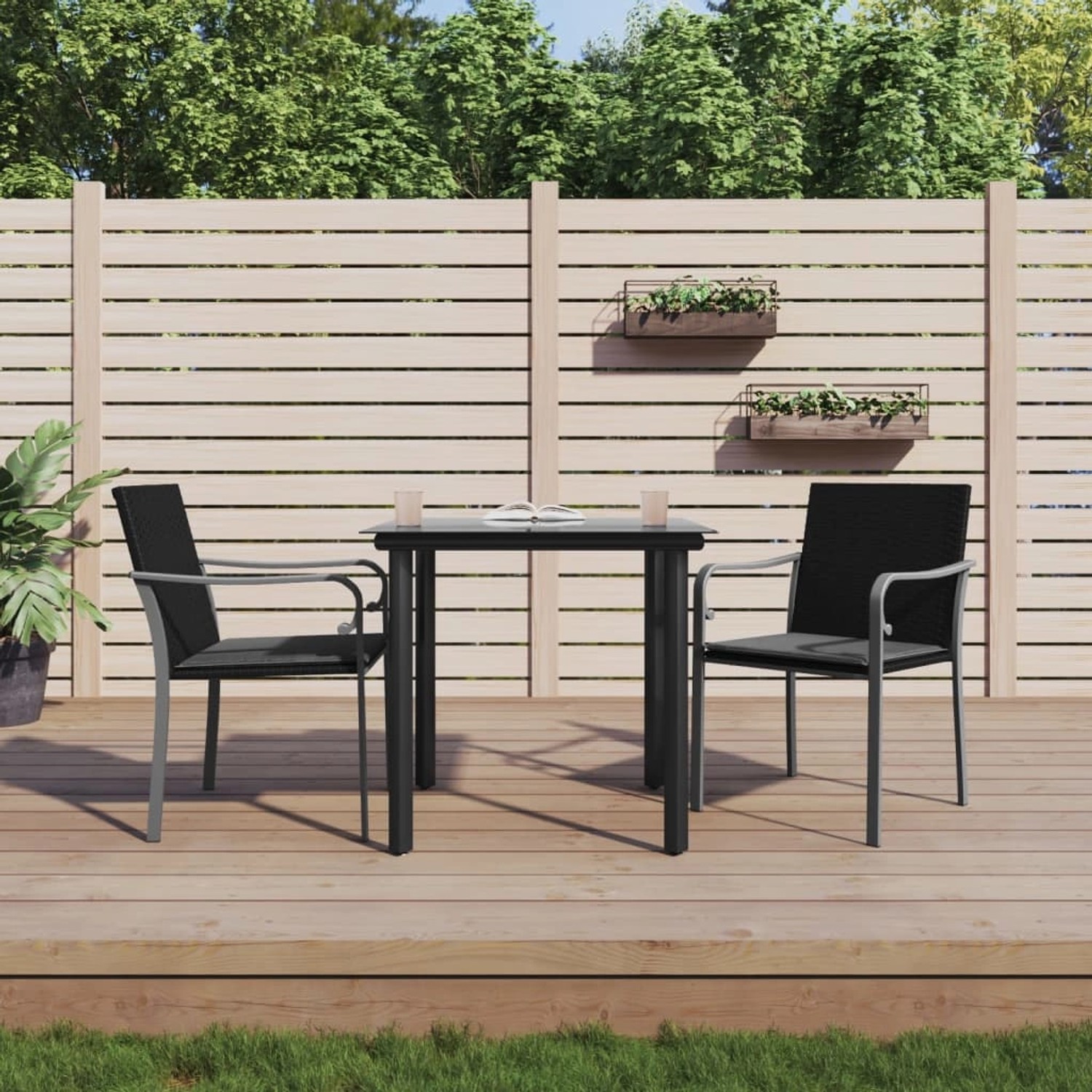 3-teilige Garten Essgruppe aus Polyrattan und Stahl. Schwarze Stühle mit Tisch auf Holzterrasse.