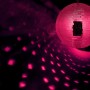 Große silberne Discokugel mit Glasfacetten, die pinke Lichtreflexe auf dunklem Hintergrund erzeugt. Ideal für Partys.
