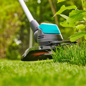 Gardena Akku-Trimmer EasyCut 23/18V P4A in Aktion beim Rasenkantenschneiden.