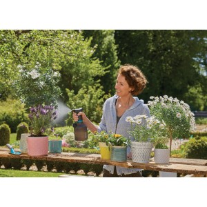 Frau benutzt Gardena EasyPump Pumpsprüher 1 l zum Bewässern von Pflanzen im Garten.