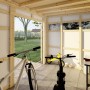 Innenansicht Bertilo Gartenhaus HPL 2 Italian Walnut mit Fahrrädern und Gartengeräten.