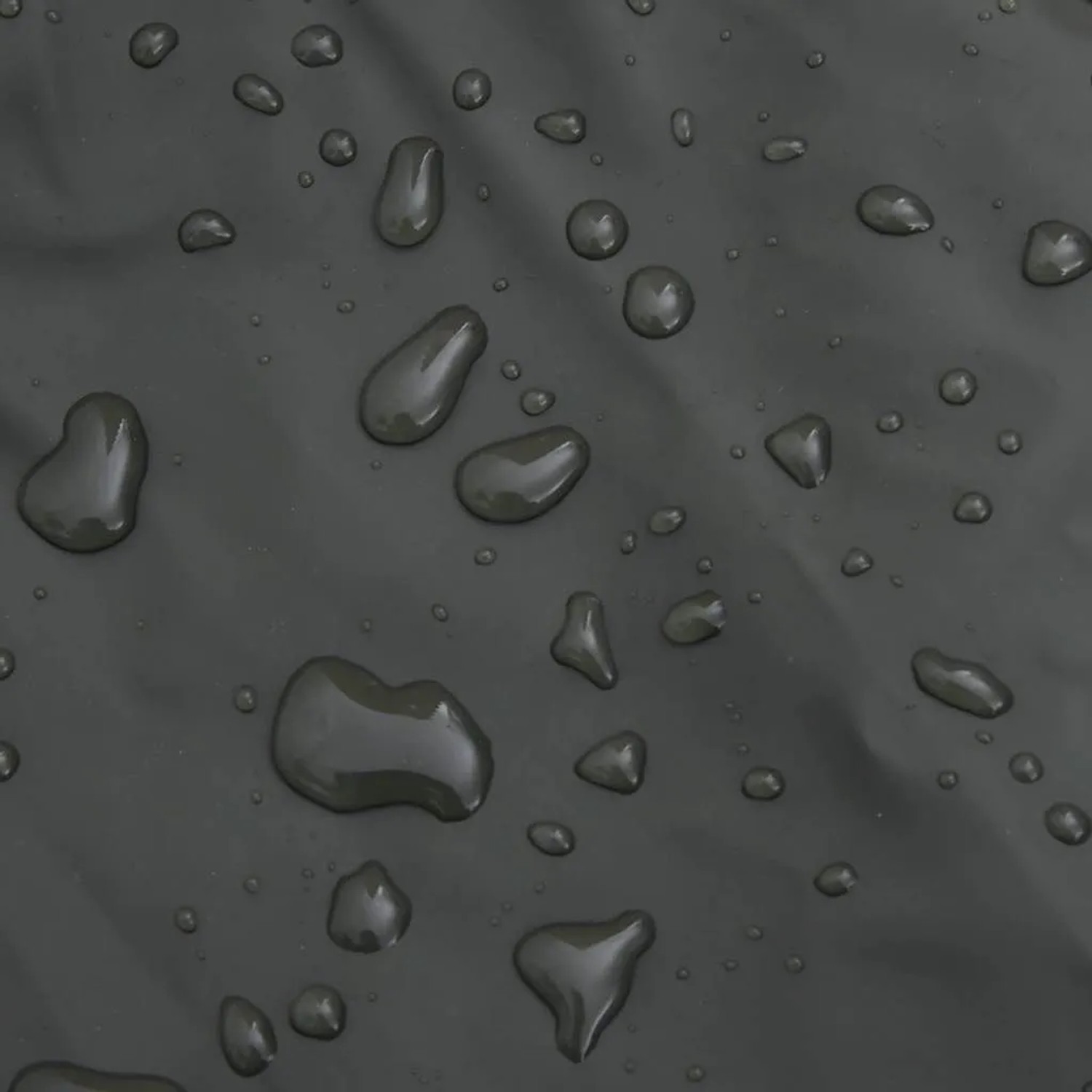 Detailaufnahme der wasserabweisenden Oberfläche einer dunkelgrünen Wathose mit Wassertropfen.