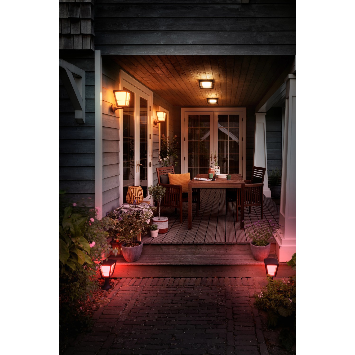 Szene mit Philips Hue Econic Wandleuchten und Gartenleuchten, die in Farbe leuchten.