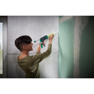 Frau benutzt wolfcraft Kartuschenpresse MG 310 Compact zum Verfugen einer Wand.
