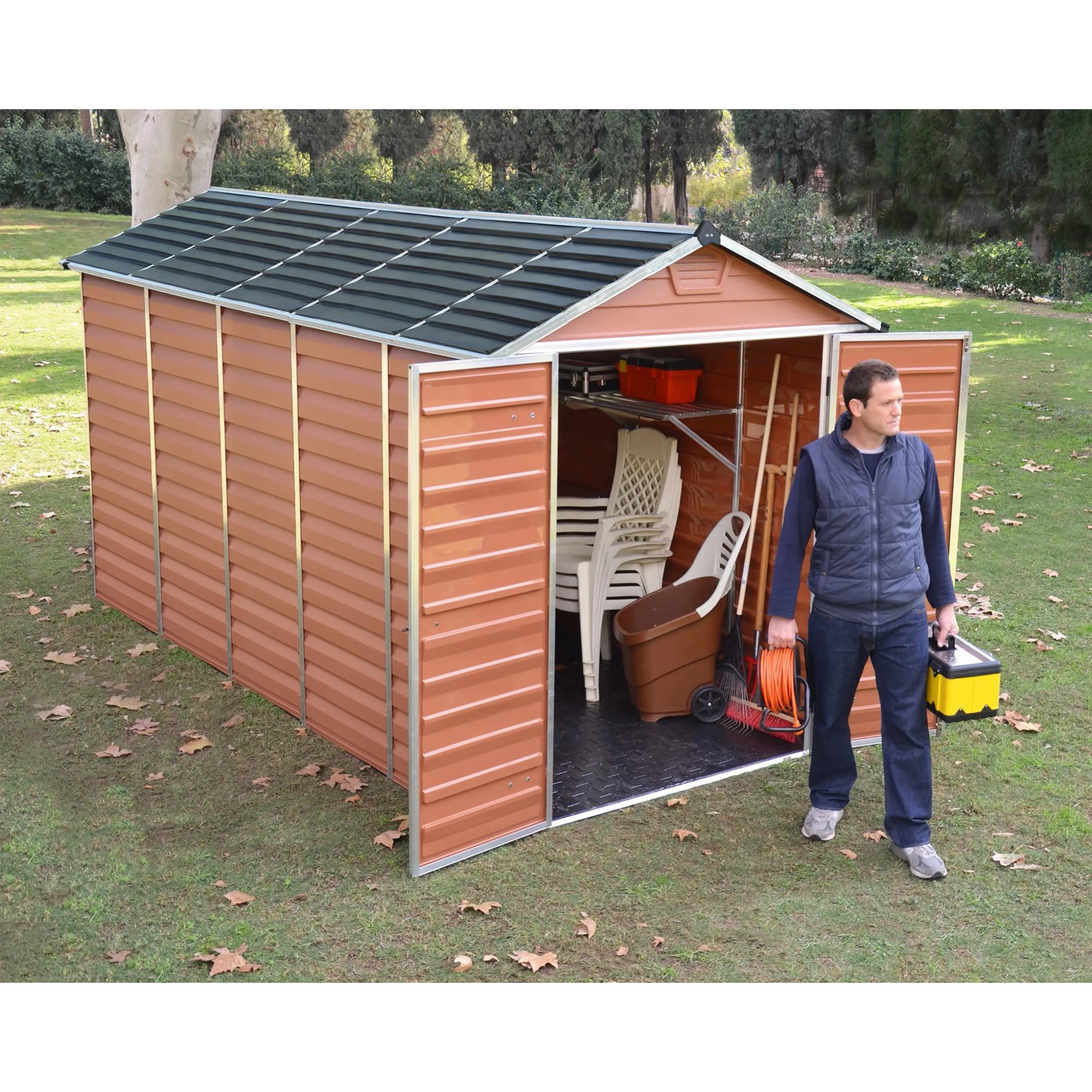Palram Canopia Gerätehaus Skylight 185x379cm Amber mit geöffneten Türen und Mann davor.