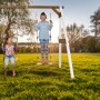 Axi Doppel-Anbauschaukel aus Holz in Weiß und Braun mit zwei Kindern beim Schaukeln im Garten.