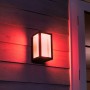 Philips Hue Impress LED-Wandleuchte, schwarz, mit farbigem Licht an Hauswand.