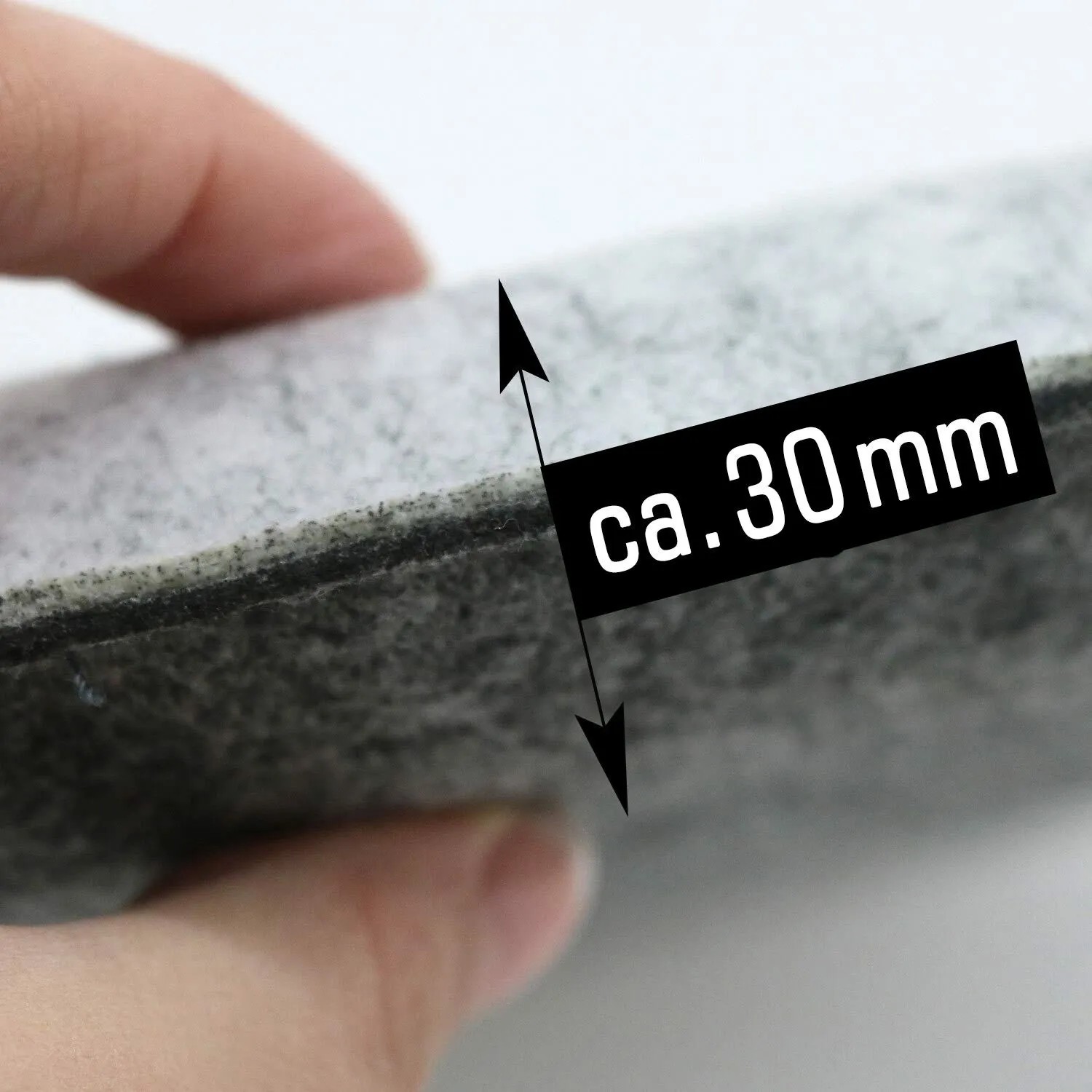 Nahaufnahme eines grauen Filz Sitzkissens, ca. 30 mm dick, von Hand leicht eingedrückt. Ideal als Stuhlpolster.