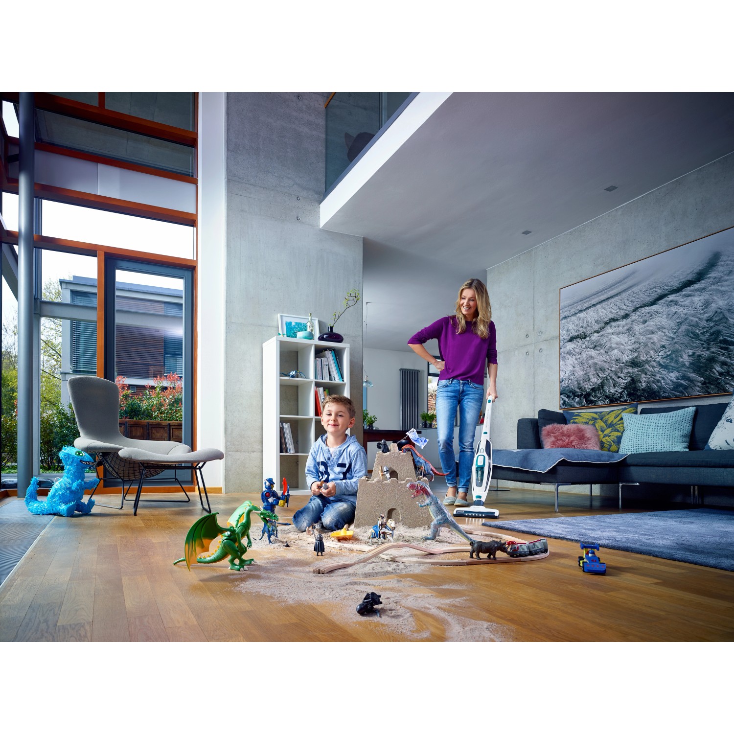 Leifheit Akku-Staubsauger Regulus PowerVac im Einsatz, Mutter saugt Spielzeugstaub, Kind spielt.