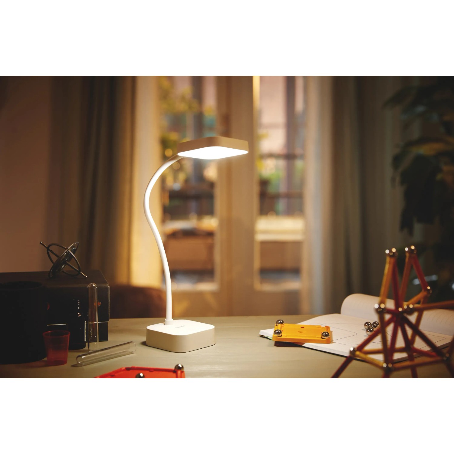 Weiße Philips LED-Tischleuchte Rock mit Akku auf Schreibtisch. Flexibler Leuchtenhals.