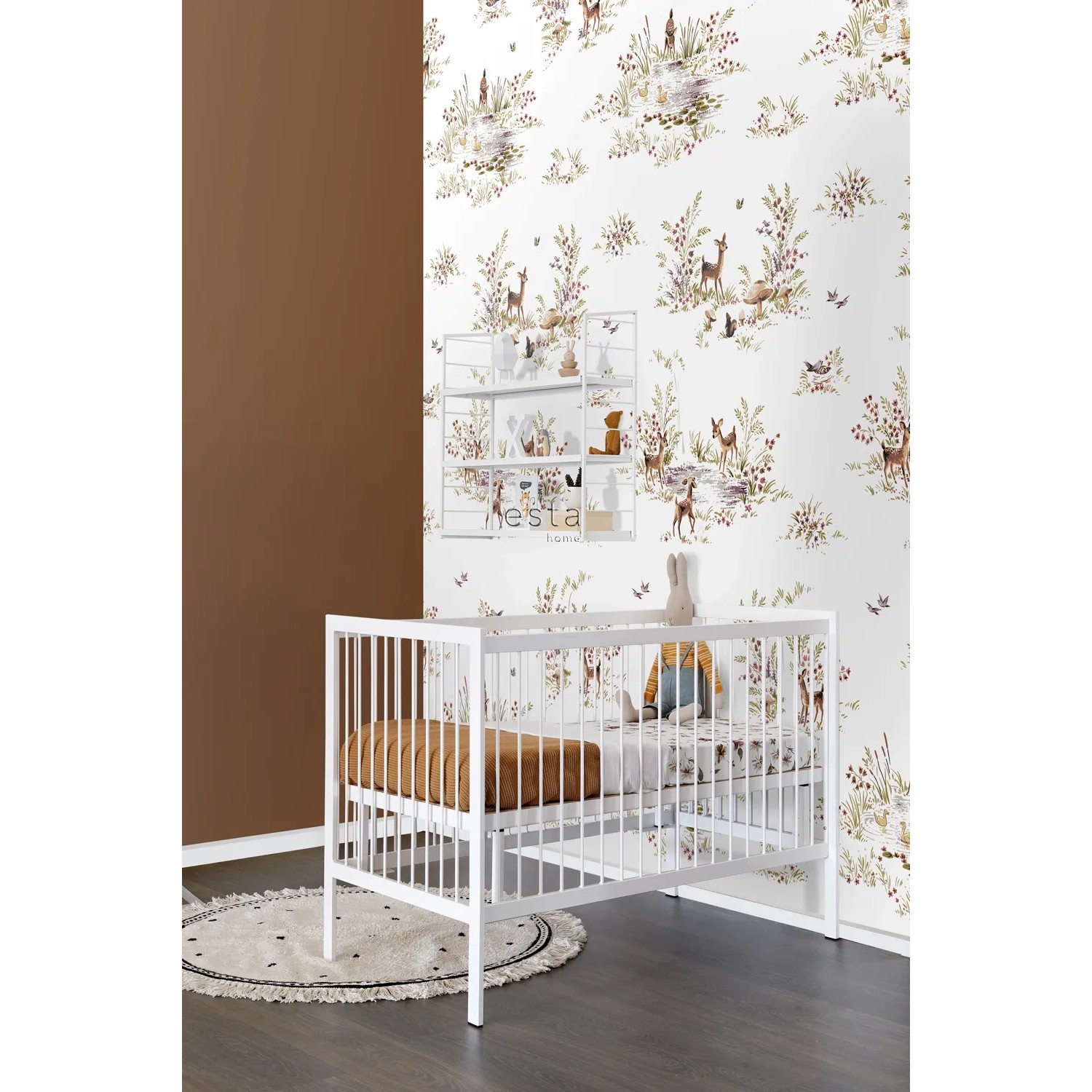 ESTAhome Fototapete Hirsche in Grün/Braun im Kinderzimmer mit weißem Gitterregal und Babybett.
