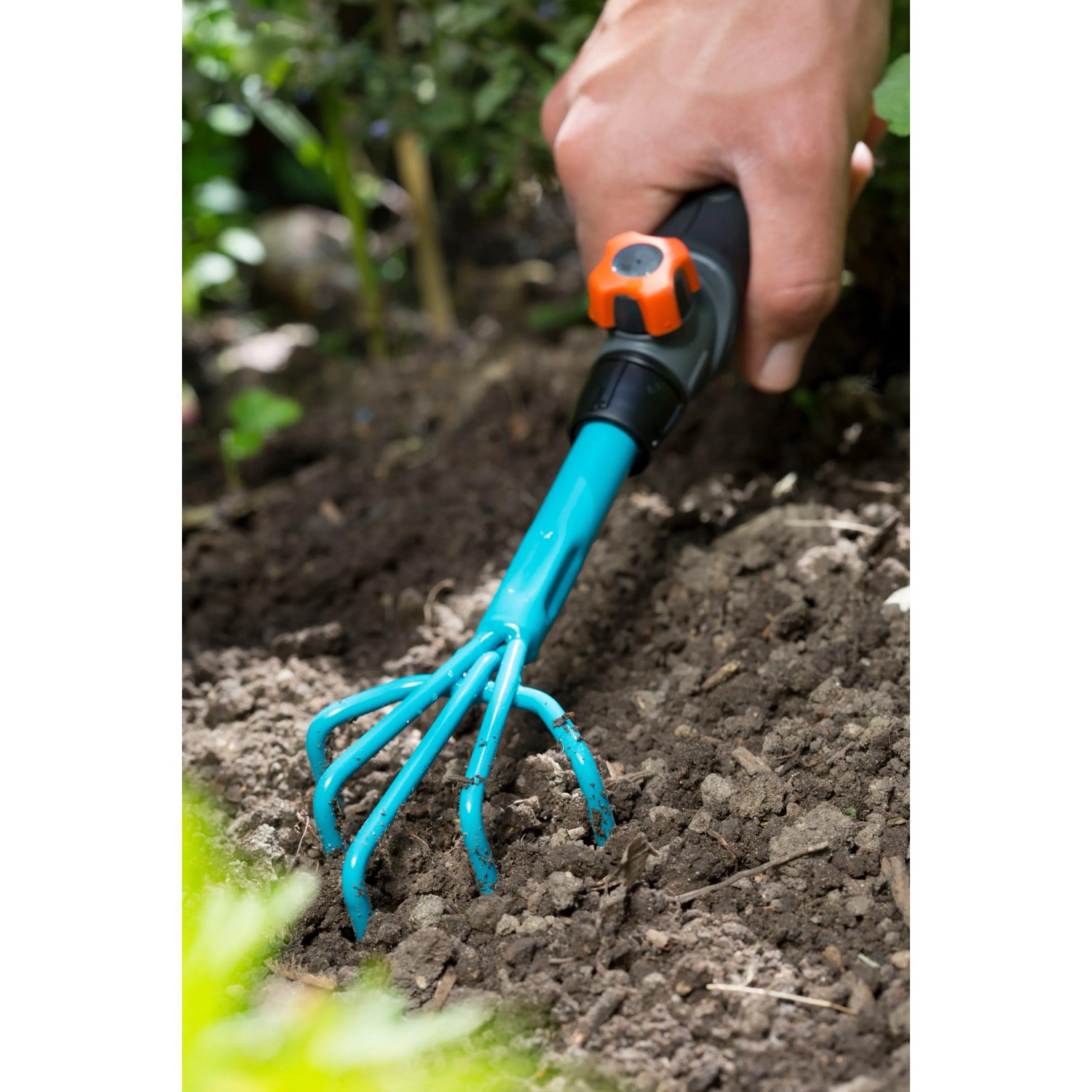 Gardena combisystem-Blumenkralle im Einsatz zum Auflockern der Erde im Garten.