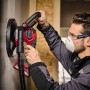 Einhell Akku-Trockenbauschleifer TP-DWS 18/225 im Einsatz beim Schleifen einer Wand. Staubabsaugung sichtbar.
