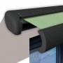 Elektrische Kassettenmarkise in Anthrazit mit lindgrünem Tuch, teilweise ausgefahren.
