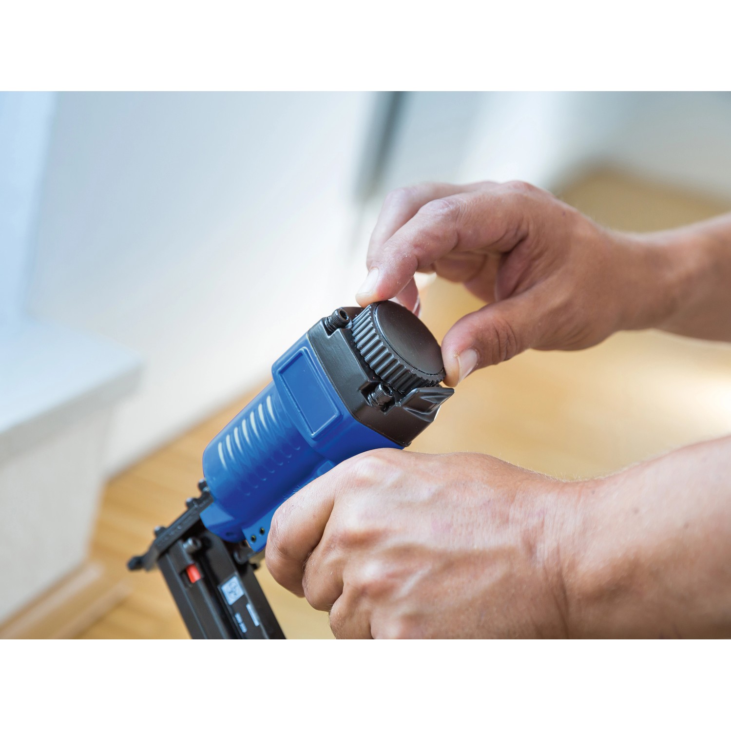 LUX Druckluft Kombi-Nagler-Set in Aktion: Hände bedienen blauen Nagler. Zubehör für Kompressoren.