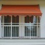 Orange-braune Angerer Klemmmarkise Exklusiv, 150x150 cm, am Balkon montiert.
