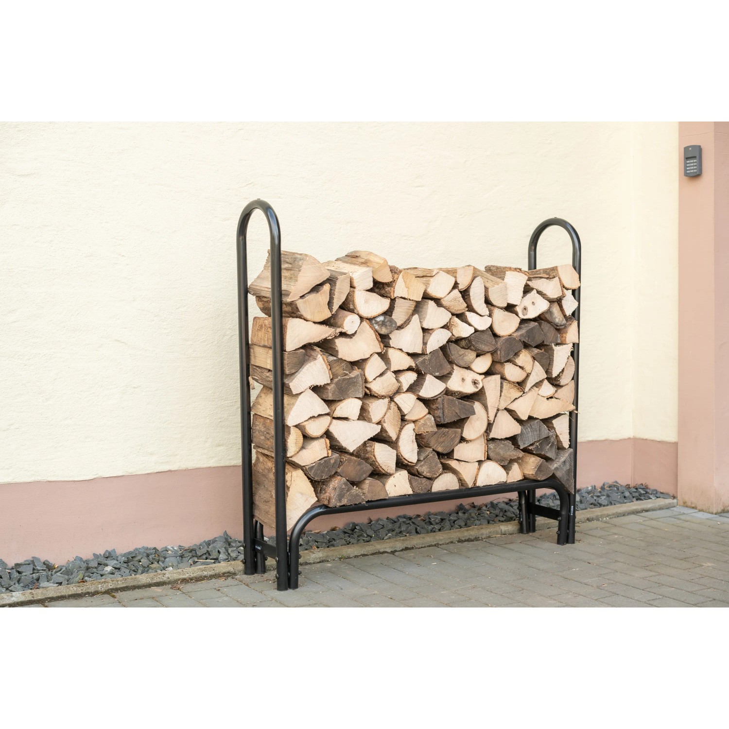 Schwarzes ShelterLogic Kaminholzregal mit Holz gefüllt. Praktische Kaminholz Lagerung.