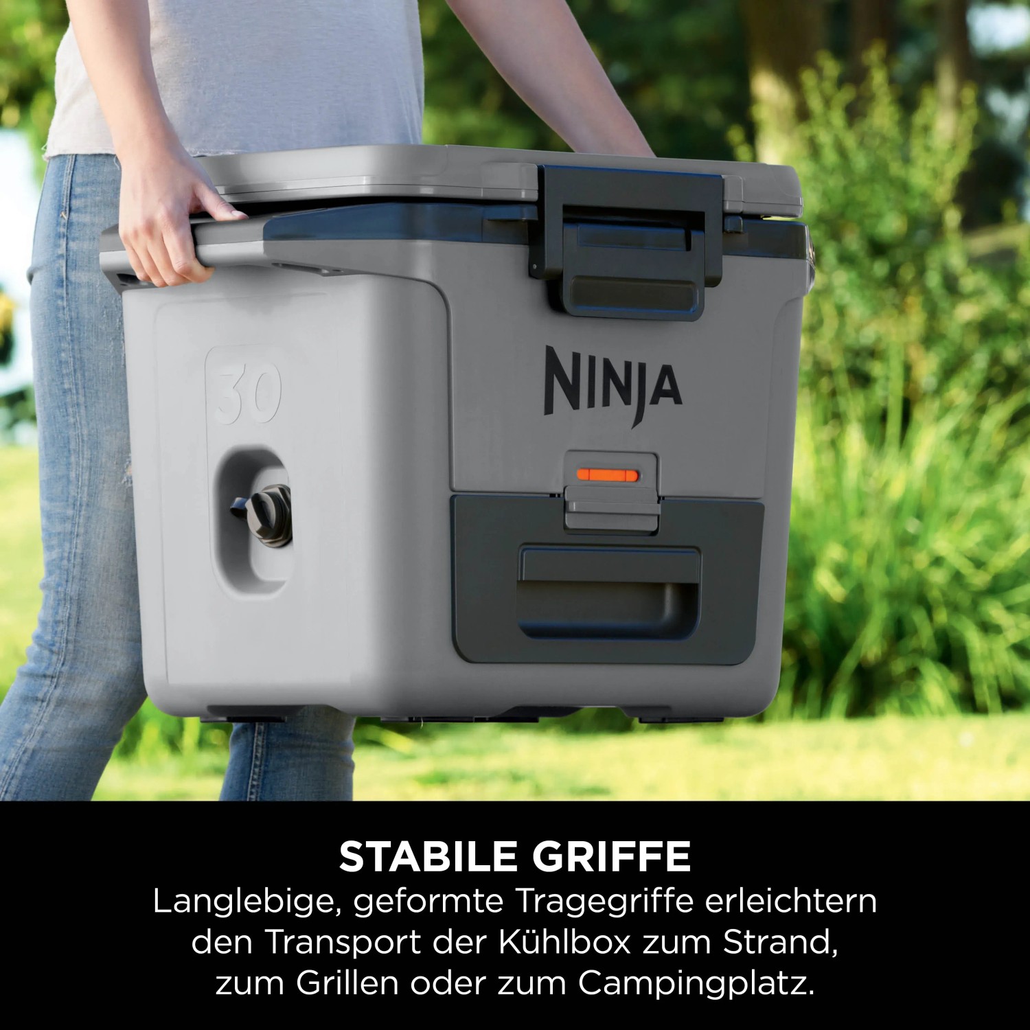 Graue Ninja Kühlbox FrostVault (28 l) mit Tragegriffen und Trockenzone wird getragen.