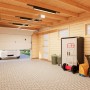 Palmako Holzgarage Rasmus mit Sektionaltor, naturbelassen. Innenansicht mit Auto und Gartengeräten.