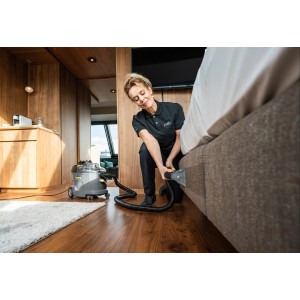 Frau reinigt Polster mit Kärcher Waschsauger Puzzi 8/1. Nass- und Trockensauger für textile Flächen.