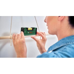 Bosch Wasserwaage (12 cm) im Einsatz: Handwerkerin richtet Holzstange aus. Kompaktes Messwerkzeug.