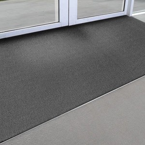 Graue KARAT Kokosmatte 50x80 cm als Fußabtreter vor einer Tür.