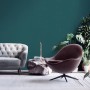 Wohnraum mit blaugrüner Vliestapete, Sofa und Sessel. Dekorative Tapete mit leichter Struktur.