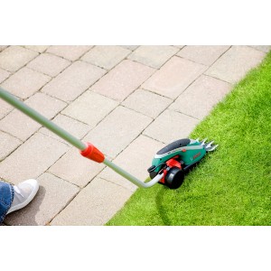 Bosch Isio Akku-Grasschere mit Teleskopstiel im Einsatz zum Rasenkantenschneiden.