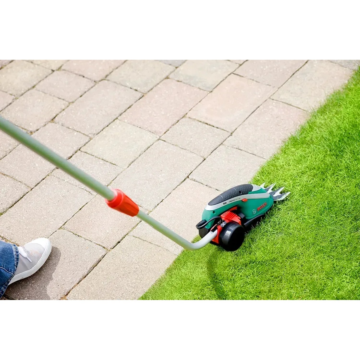 Bosch Isio Akku-Grasschere mit Teleskopstiel im Einsatz zum Rasenkantenschneiden.