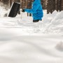 Person schaufelt Schnee mit dem Fiskars Schneeräumer Telescopic X-series.