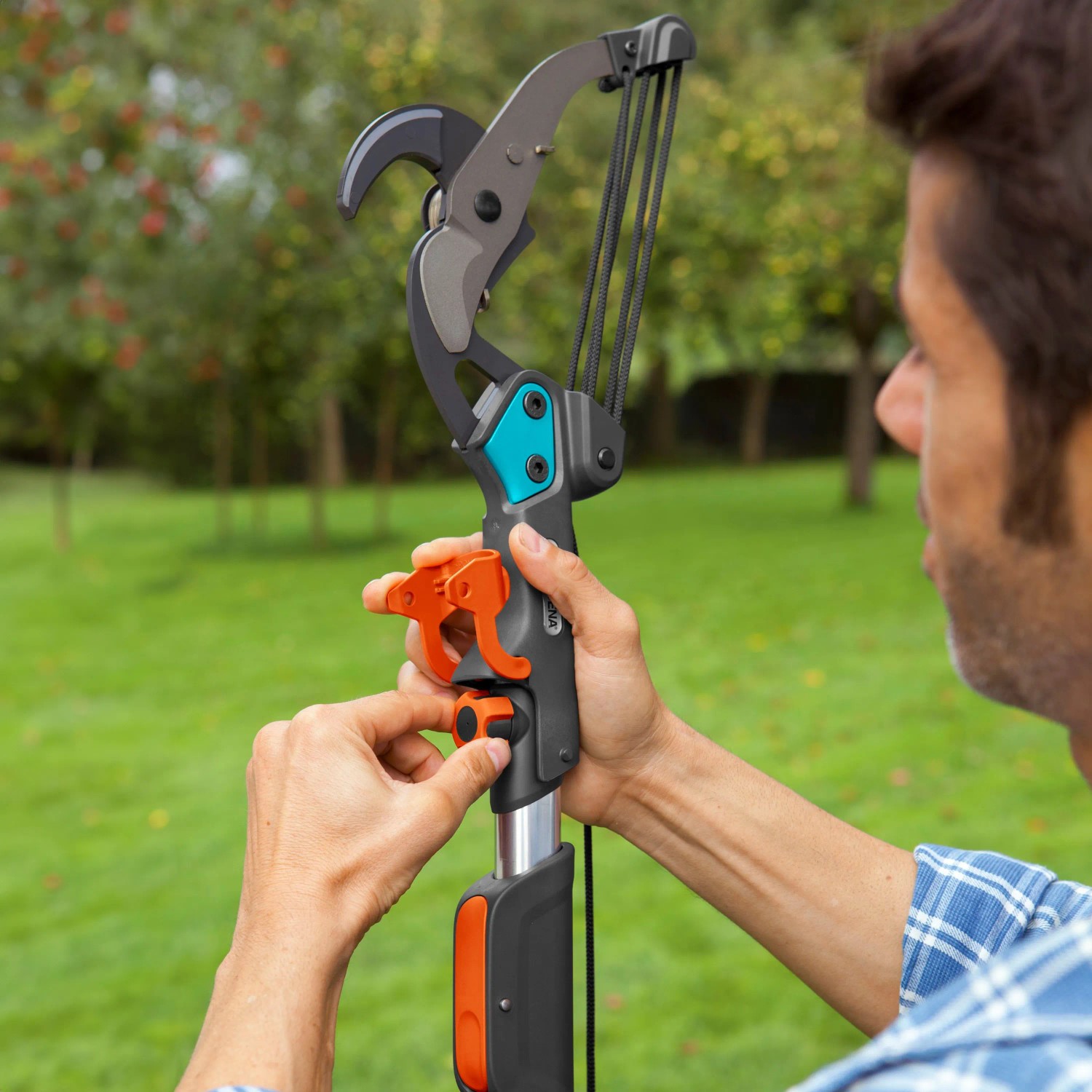 Gardena Amboss-Baumschere in Nutzung: Mann bedient Gartenschere für Äste im Garten.