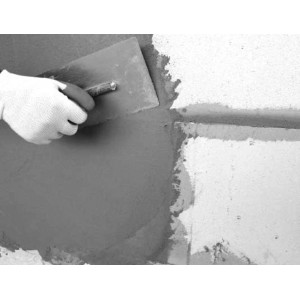 Auftragen von Tassullo Klebe- und Armierungsmörtel auf eine Wand. Geeignet für Vollwärmeschutz-Systeme.