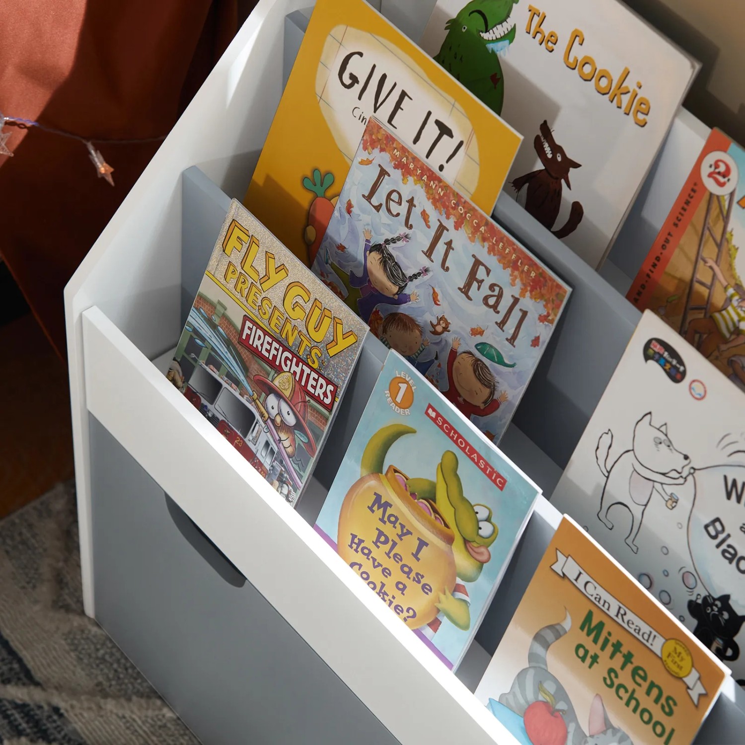 Weißes Kinder Bücherregal mit 3 Ablagen und Spielzeugtruhe, gefüllt mit Kinderbüchern.