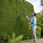 Mann schneidet hohe Hecke mit Kärcher Akku-Teleskop-Heckenschere PHG 18-45 Battery.