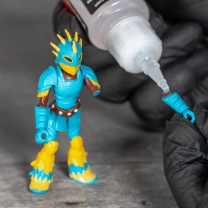 HG Power Glue Aktivator zum Pinseln beim Kleben einer Spielzeugfigur.