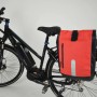 Fischer Fahrrad-Gepäckträgertasche, wasserdicht, schwarz-orange, am Fahrrad befestigt.