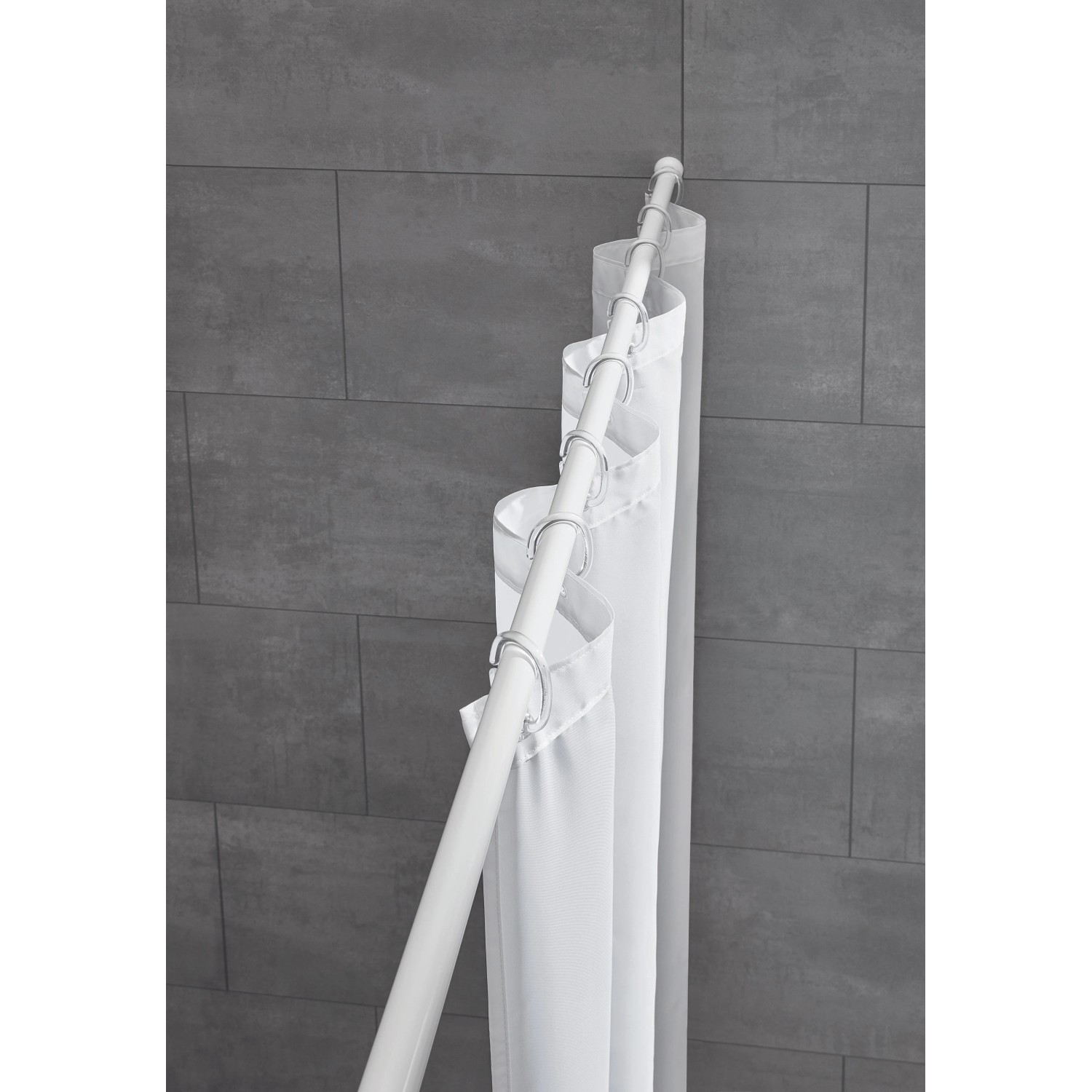 Weiße Kleine Wolke Federstange (75-125cm) mit Duschvorhangringen vor grauer Wand.