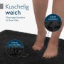 Füße auf weicher, schwarzer Beautissu BeauMare FL Hochflor Badematte. Rutschfest, schnell trocknend für Bad & WC.