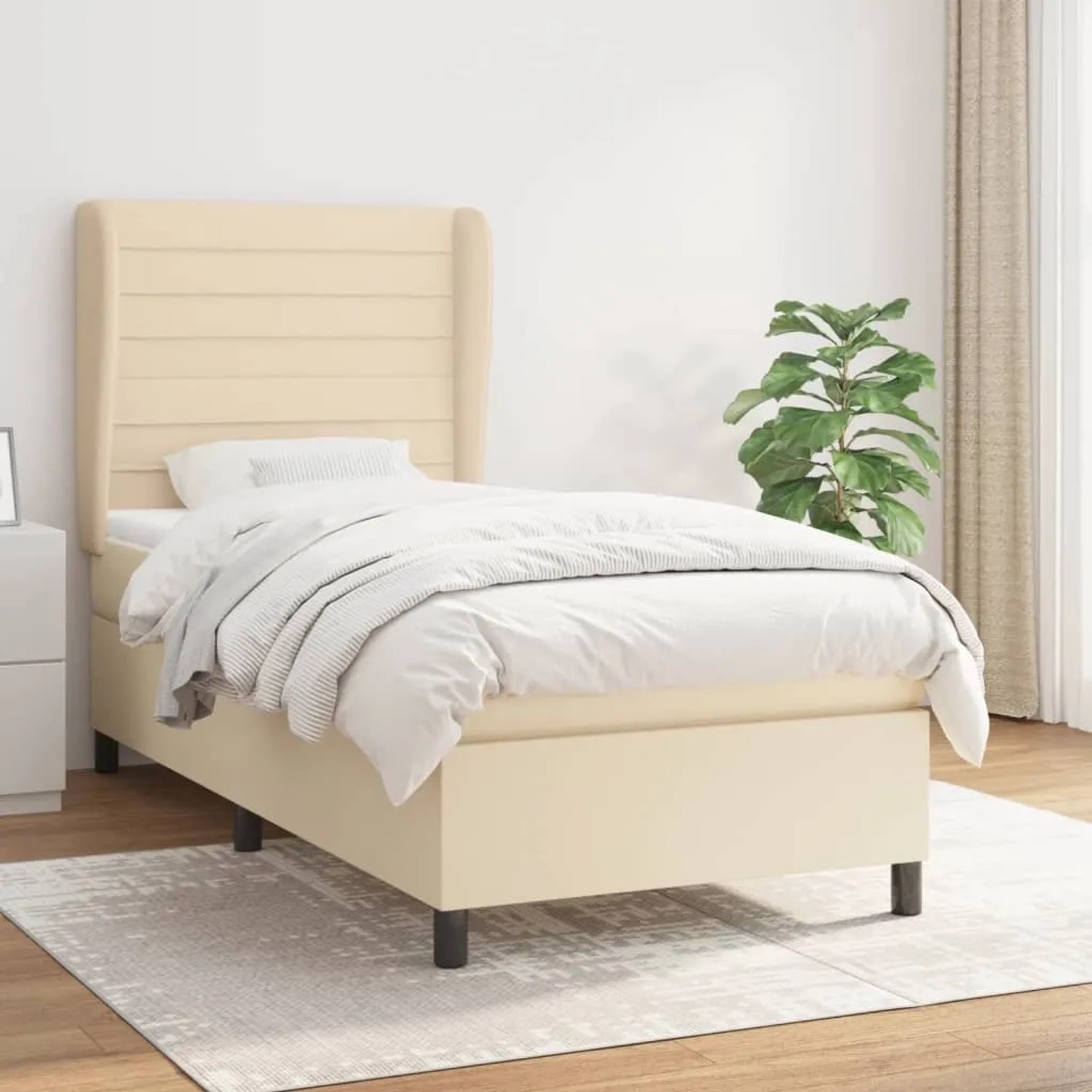 Cremefarbenes Boxspringbett 100x200 cm mit Stoffbezug und Matratze.