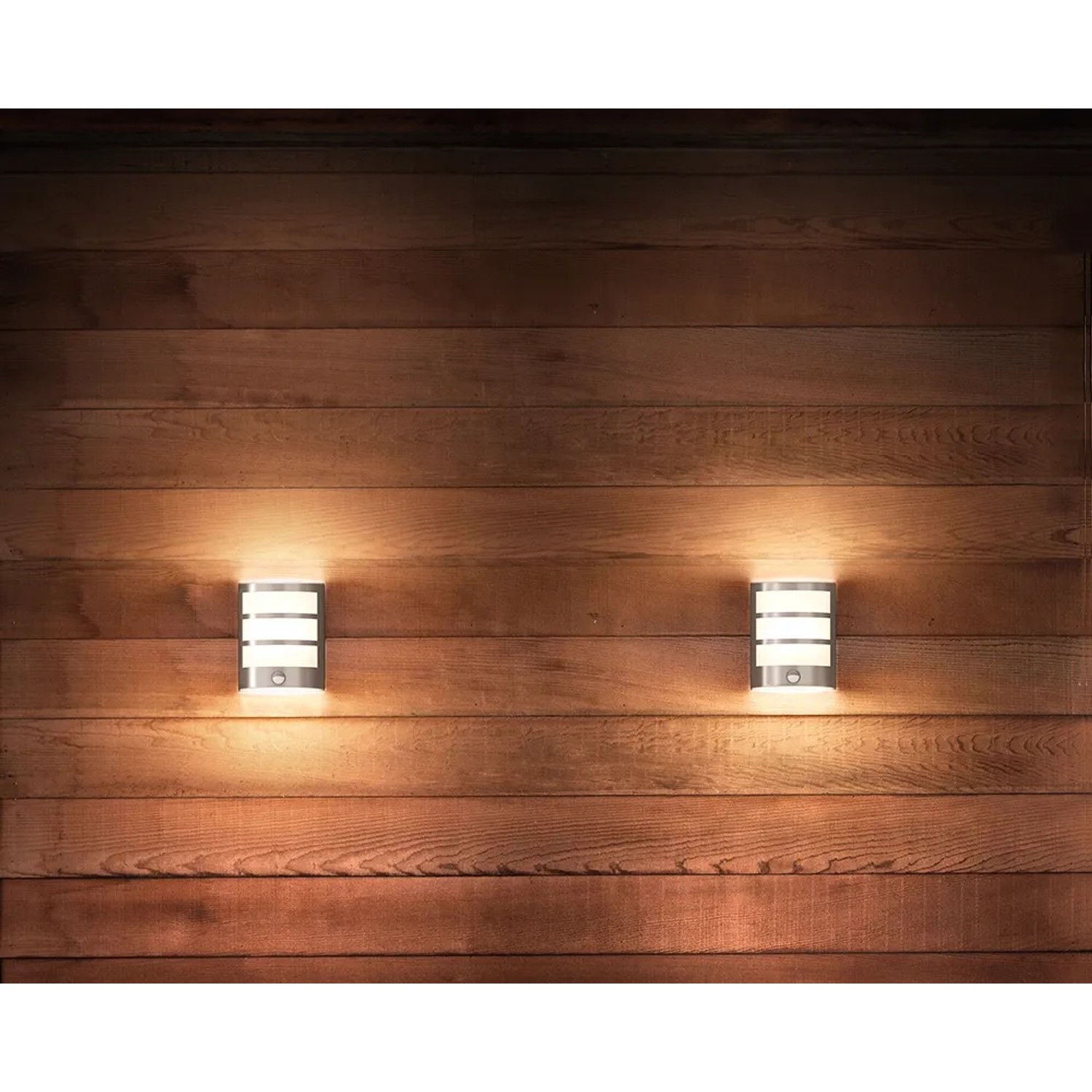 Zwei Philips LED-Außenwandleuchten Python aus Edelstahl mit Bewegungsmelder an Holzwand.