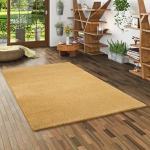 Quadratischer, curryfarbener Snapstyle Hochflor Shaggy Teppich Palace, 133x133 cm, auf Holzboden.