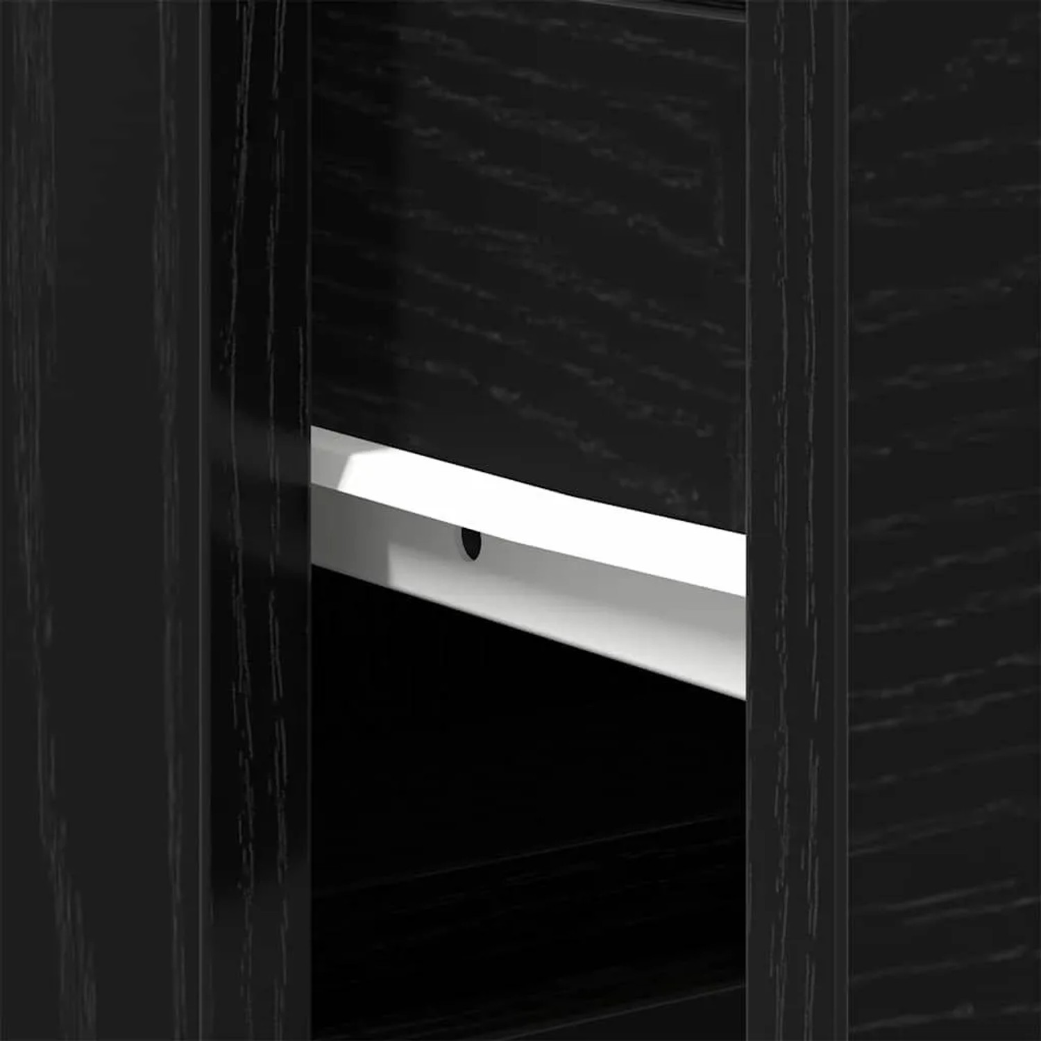 Detailaufnahme: Schwarzer Waschbeckenunterschrank in Eichen-Optik mit Regalboden.