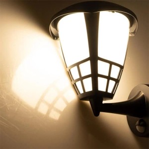 Schwarze ChiliTec Außen-Wandleuchte TELARANA aus Kunststoff mit Gittermuster, warmweißem Licht und PIR-Sensor, leuchtet an der Wand.