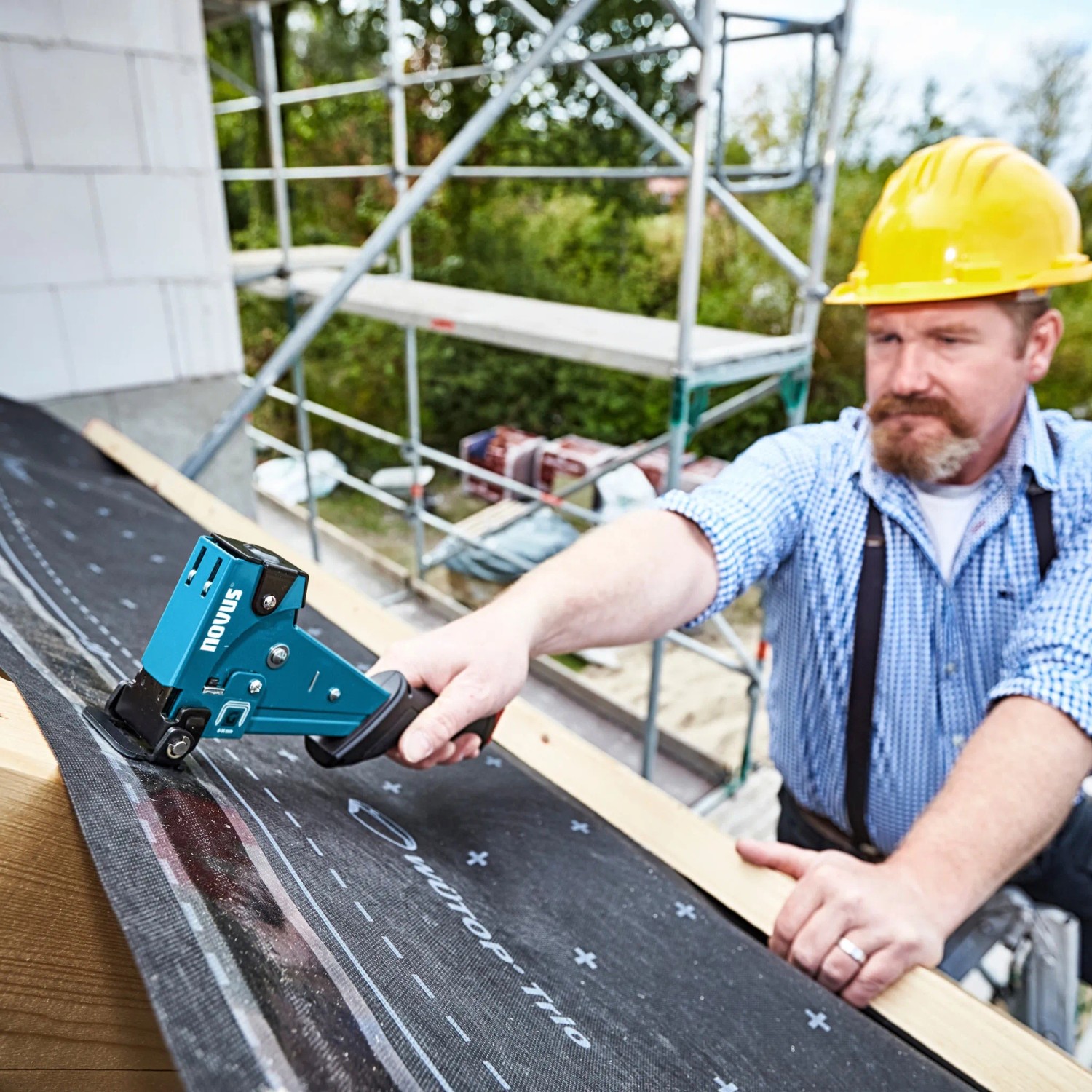 Handwerker bei der Arbeit mit Novus Hammertacker J-055 auf einer Baustelle.