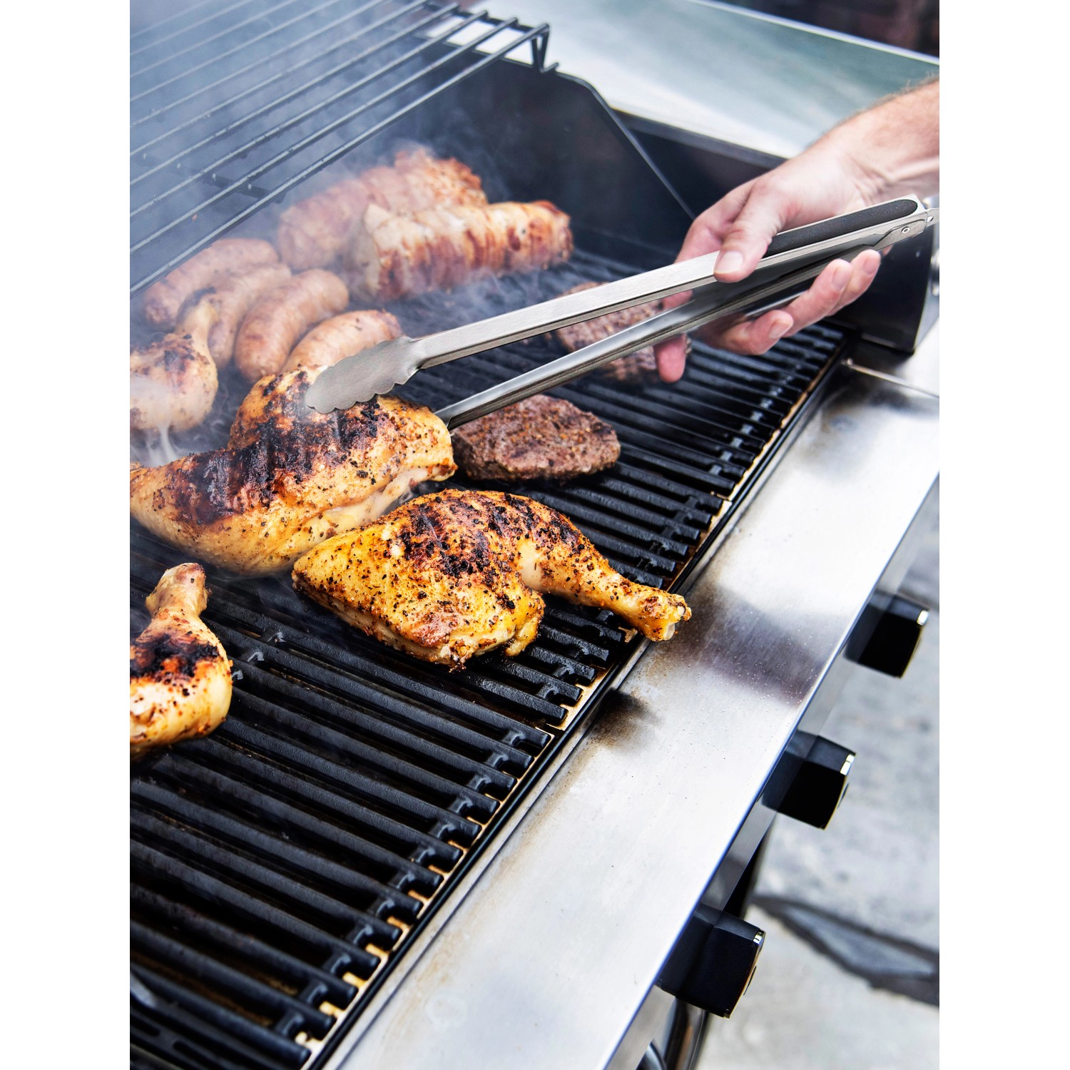 Char-Broil Grillzange im Einsatz: Grillgut (Hähnchen, Würstchen, Burger) wird gewendet.