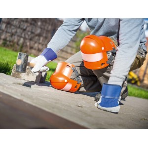 Handwerker mit LUX Knieschoner mit Gelenk beim Pflastern. Orange Knieschoner für optimalen Knieschutz.