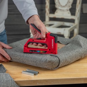 Roter Arrow Handtacker T501 beim Polstern eines Stuhls. Klammern sichtbar.