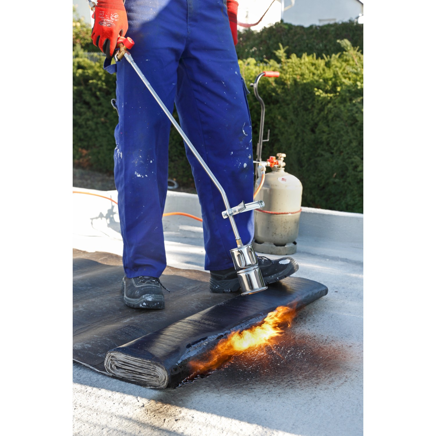 Rothenberger RoMaxi Anwärmbrennerset beim Verschweißen von Bitumenbahnen. Lötgerät mit Propangasflasche.