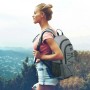 Grauer Bomoe IceBreezer Kühlrucksack (25L) mit Trägern vor Landschaft.